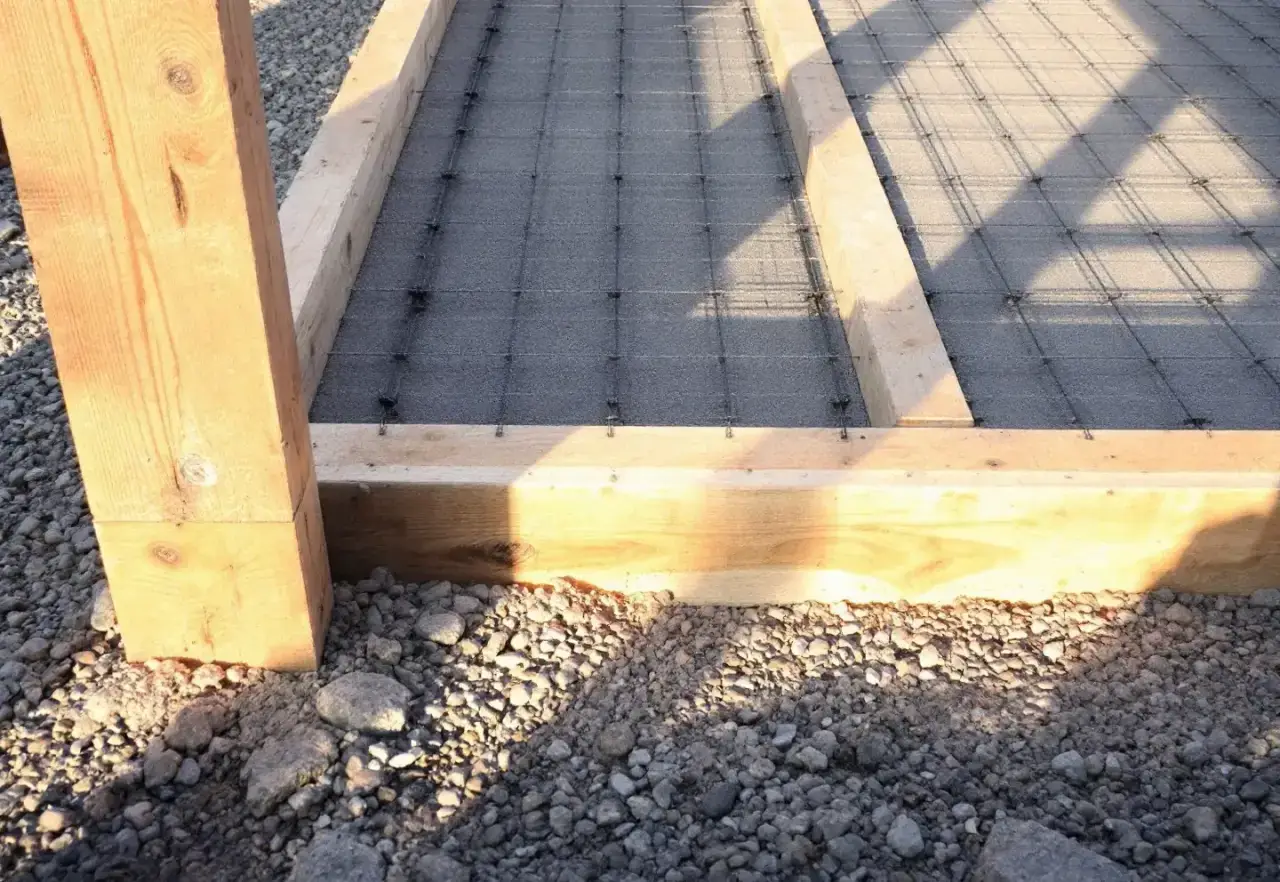 Timber formwork and steel mesh set out over compacted base before a pour