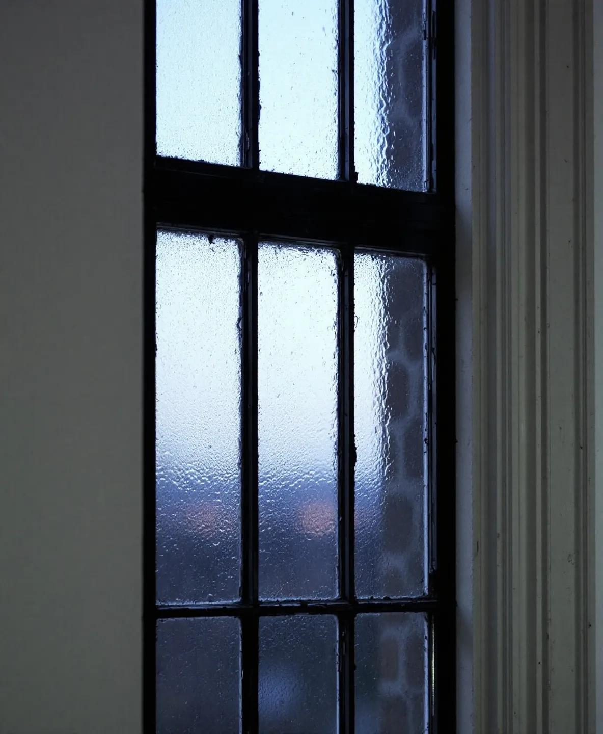 Grey-violet dusk light through the leadlight window