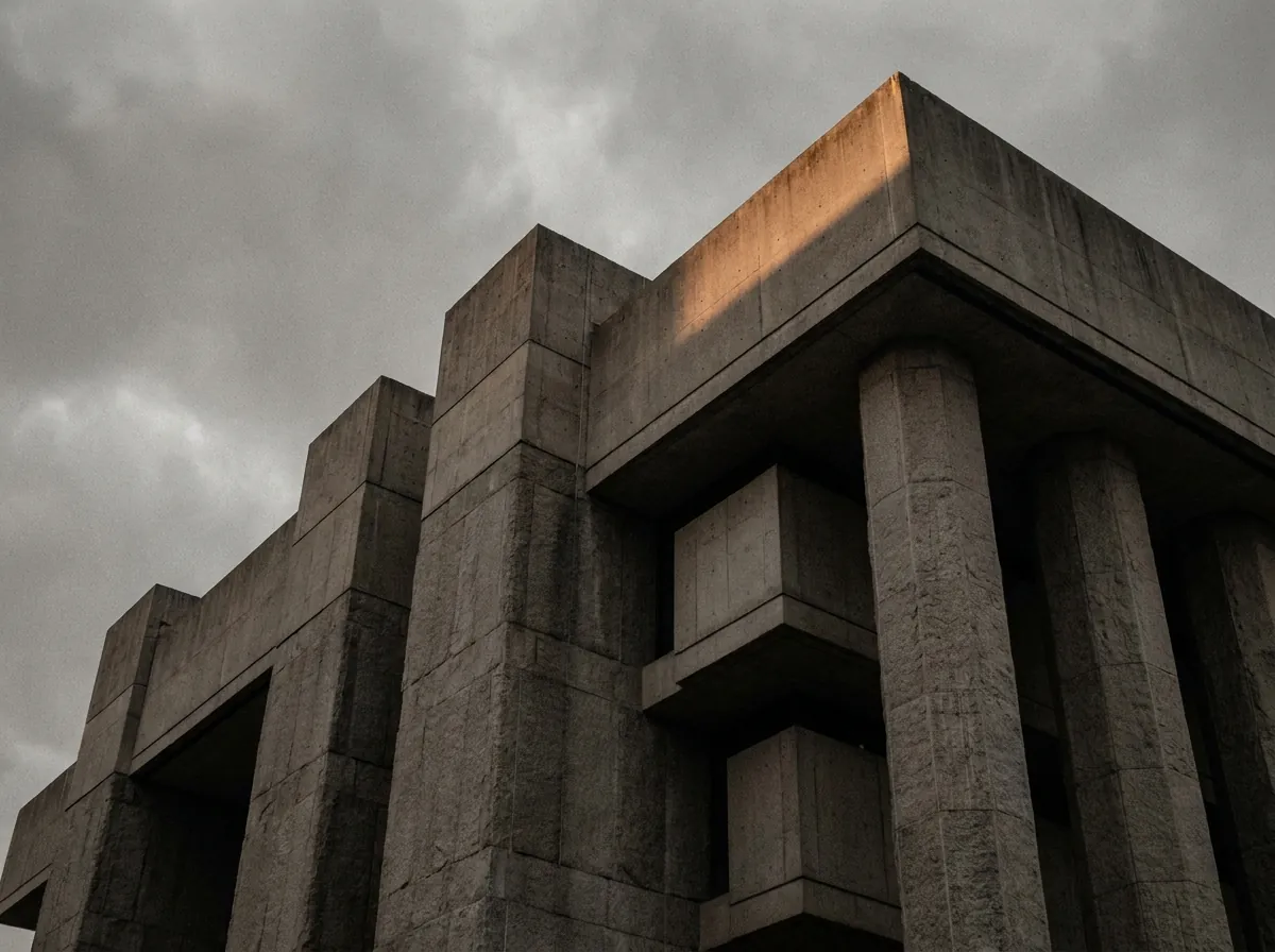 Brutalist courthouse facade in cold stone, dawn light on its upper edge