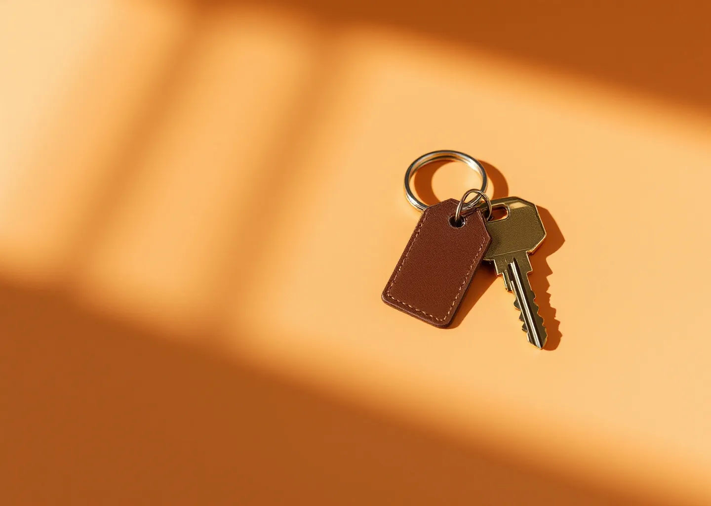 A ring of house keys with a leather tag on an amber background