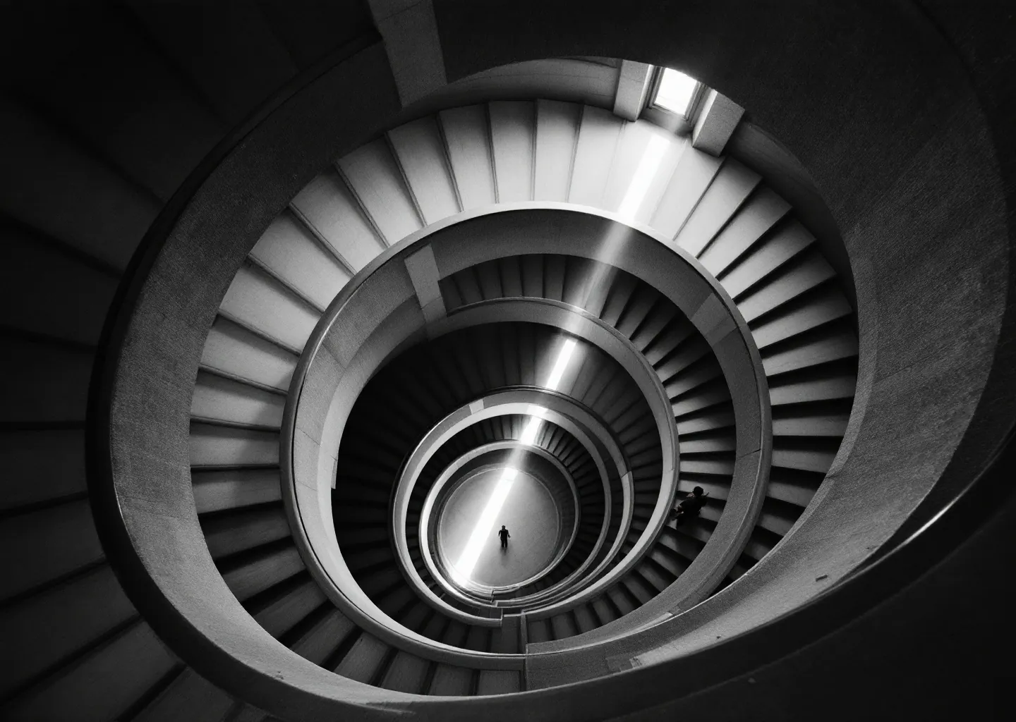 Spiral stairwell from above, one figure below