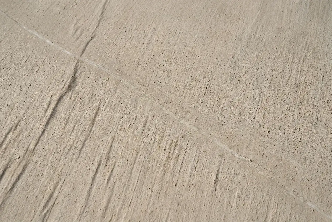 Travertine in close detail, a single pale vein crossing the stone